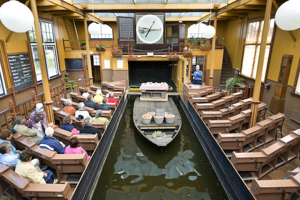 Het afmijnlokaal van Museum BroekerVeiling met bezoekers en een schuit in het water